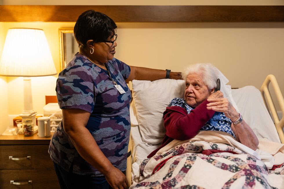 Jackie Conteh, cuidadora de adultos mayores originaria de Sierra Leona, visita a la residente...