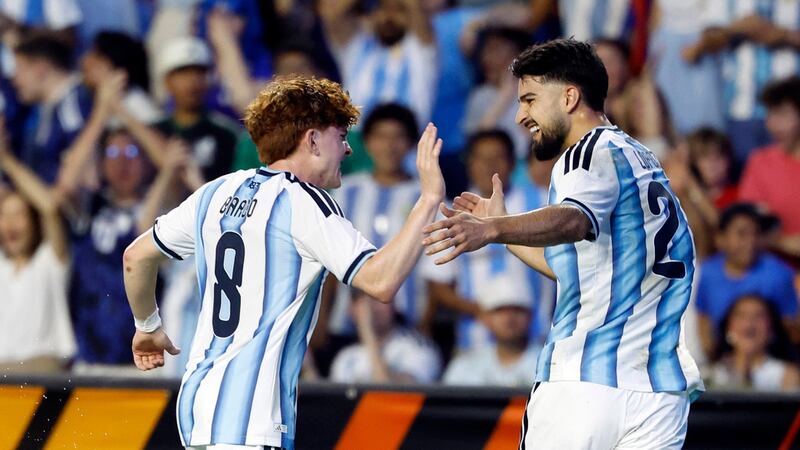 El mediocampista de Argentina, Valentín Barco (8), celebra con el delantero José López (21)...