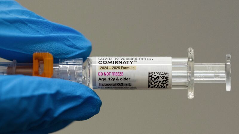 ARCHIVO - Un farmacéutico sostiene una dosis de una vacuna contra el covid19 de Pfizer y...