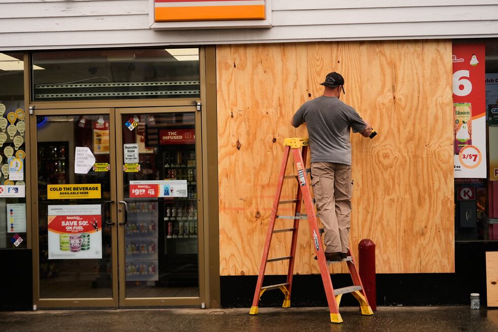 Jason Coffey coloca tablones en una tienda en una gasolinera mientras el huracán Isaías se...