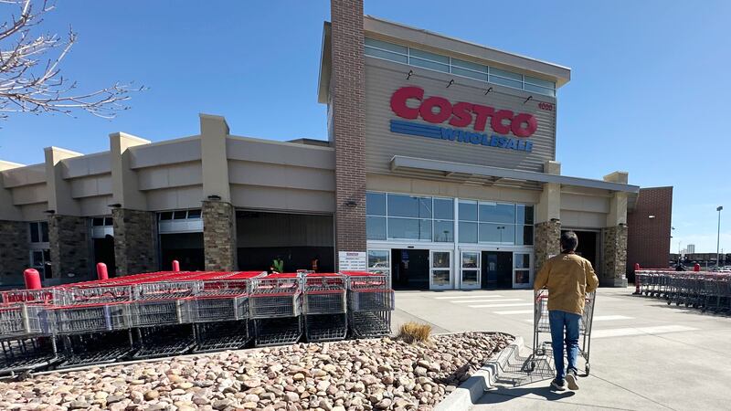ARCHIVO – Un comprador solitario empuja un carrito hacia la entrada de un almacén de Costco,...
